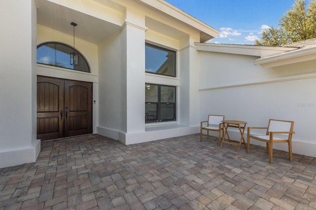 view of exterior entry with a patio area