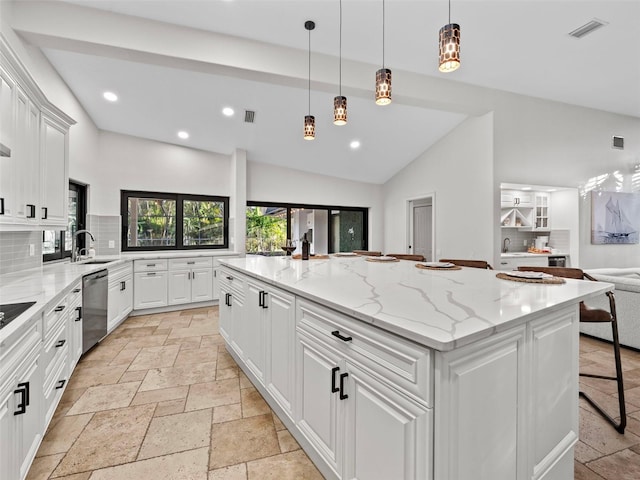 kitchen with white cabinetry, light stone countertops, stainless steel dishwasher, and a center island