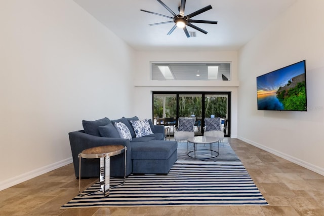 living room with a high ceiling and ceiling fan