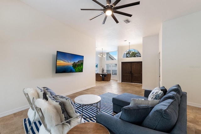 living room with ceiling fan with notable chandelier and lofted ceiling