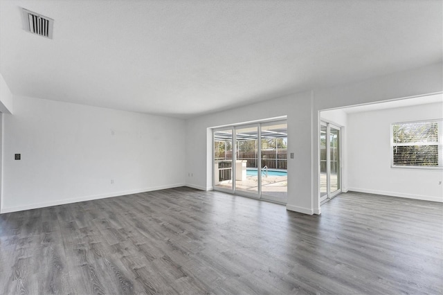 unfurnished room featuring wood-type flooring and a textured ceiling