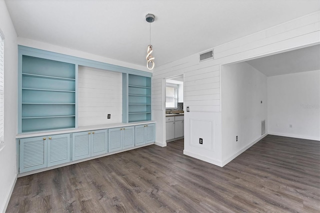 unfurnished dining area featuring sink and dark hardwood / wood-style flooring