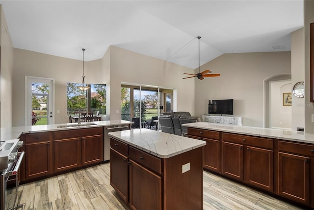 kitchen featuring sink, a center island, vaulted ceiling, appliances with stainless steel finishes, and light hardwood / wood-style floors