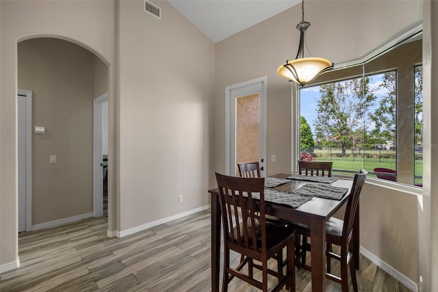 dining area featuring vaulted ceiling and light hardwood / wood-style flooring