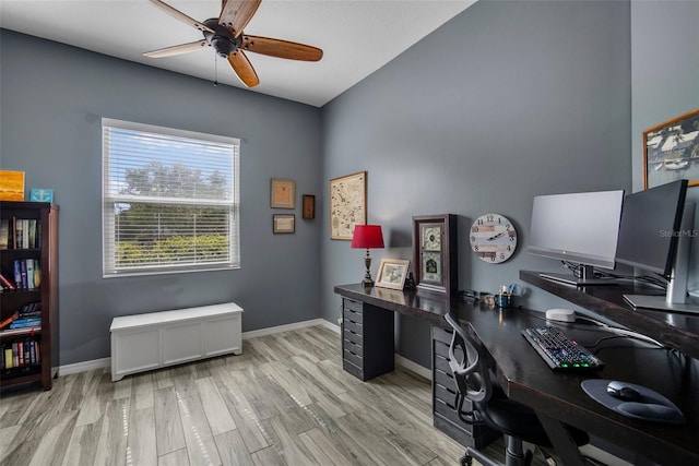 home office with light hardwood / wood-style floors and ceiling fan