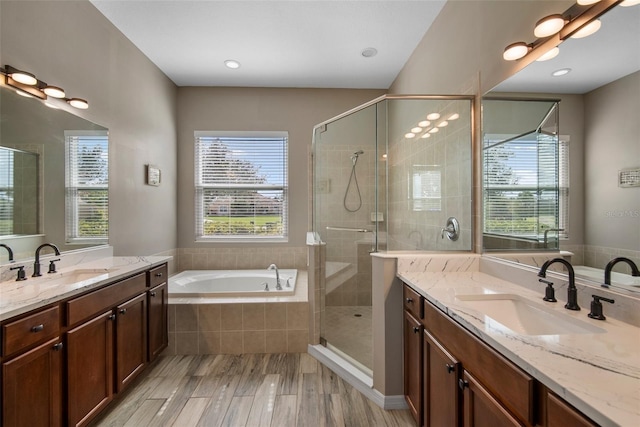 bathroom with vanity, hardwood / wood-style flooring, and shower with separate bathtub