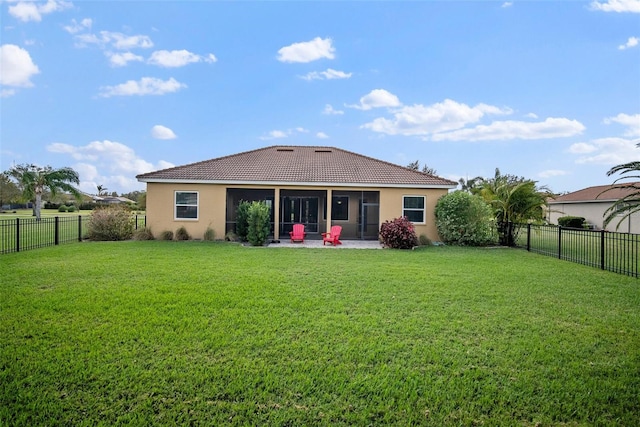 rear view of property with a patio, a yard, and a sunroom