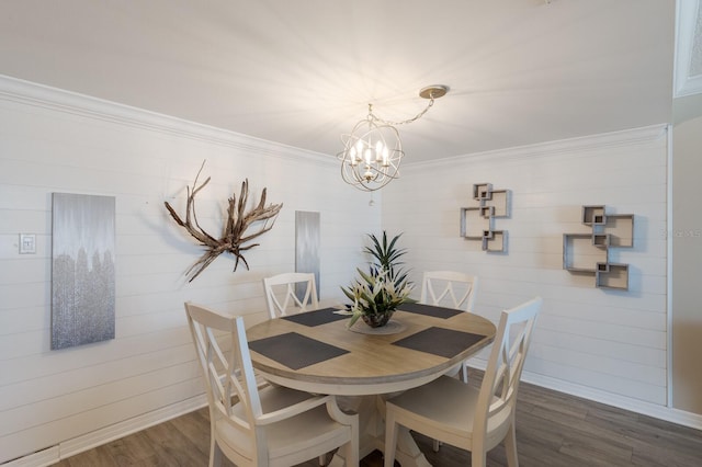 dining room with crown molding, dark hardwood / wood-style flooring, a chandelier, and wooden walls