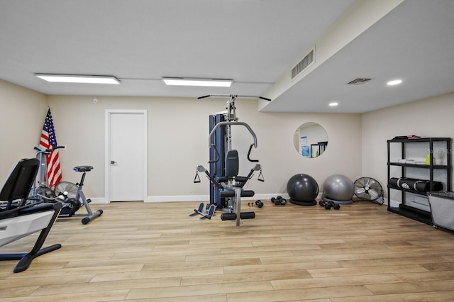 exercise room with light hardwood / wood-style flooring