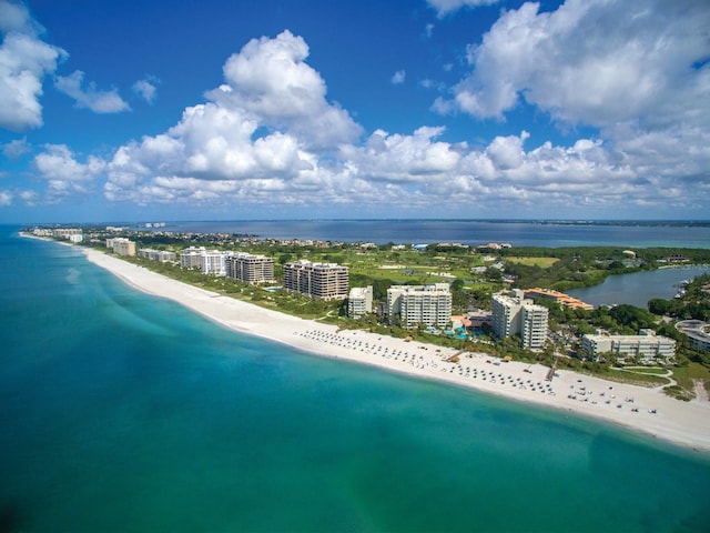 drone / aerial view featuring a water view and a beach view