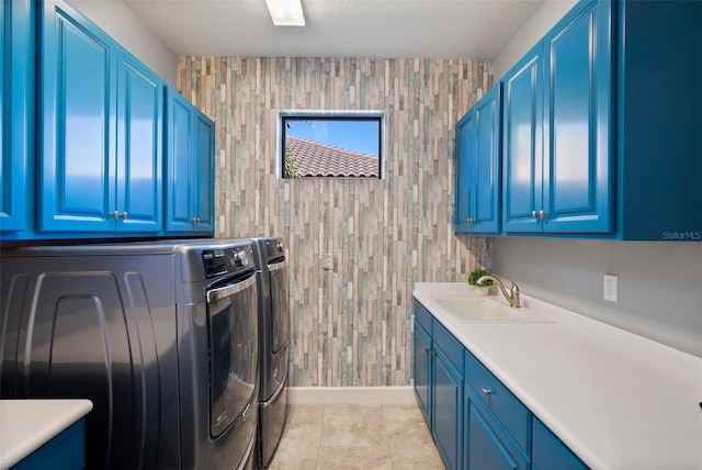 washroom featuring sink, washing machine and dryer, light tile patterned floors, and cabinets