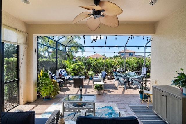 view of patio / terrace with an outdoor living space, ceiling fan, and glass enclosure