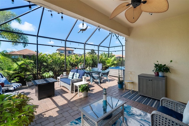 view of patio featuring ceiling fan, glass enclosure, and outdoor lounge area