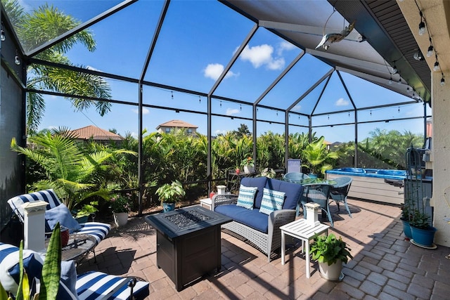 view of patio / terrace with a lanai, an outdoor living space with a fire pit, and a swimming pool