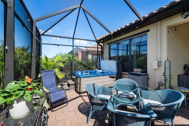 view of patio / terrace with a hot tub and glass enclosure