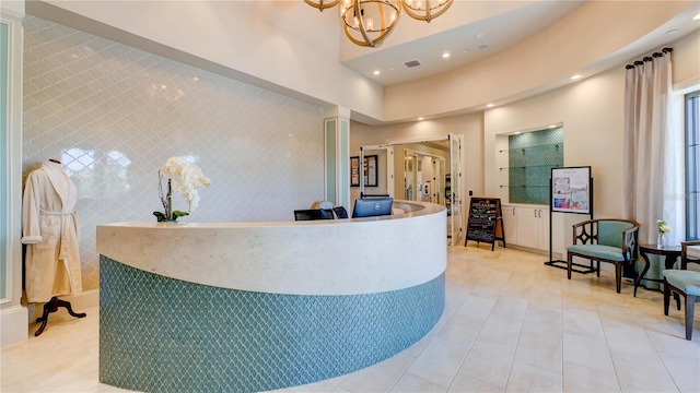 welcome area featuring decorative columns and a chandelier