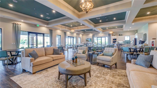 living room with beamed ceiling, coffered ceiling, a notable chandelier, and hardwood / wood-style flooring