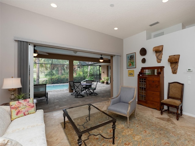 living room featuring a textured ceiling and ceiling fan