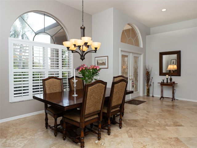 dining space featuring french doors and a notable chandelier