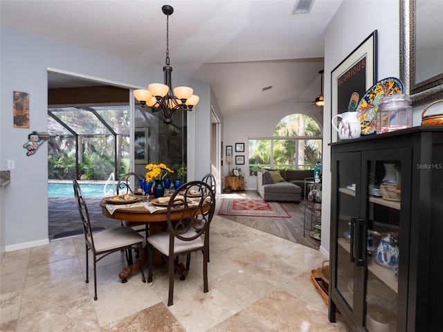 dining area with ceiling fan with notable chandelier and lofted ceiling