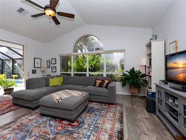 living room featuring vaulted ceiling, hardwood / wood-style flooring, and a healthy amount of sunlight