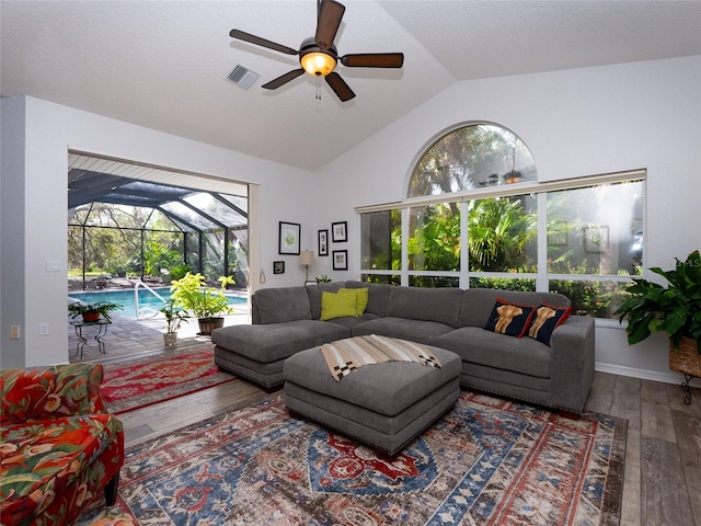 living room with hardwood / wood-style flooring, ceiling fan, and lofted ceiling