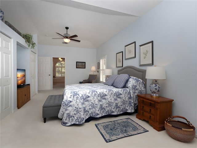 bedroom featuring a closet, light carpet, ceiling fan, and connected bathroom