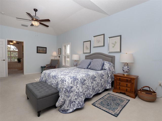 bedroom featuring light carpet, lofted ceiling, ceiling fan, and connected bathroom