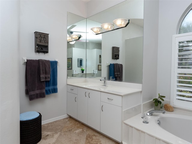 bathroom with a wealth of natural light, vanity, and a bathing tub