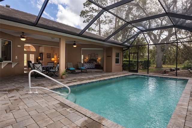 view of pool featuring an outdoor living space, a patio area, a lanai, and ceiling fan