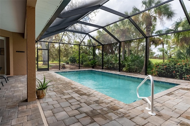 view of swimming pool with glass enclosure and a patio area