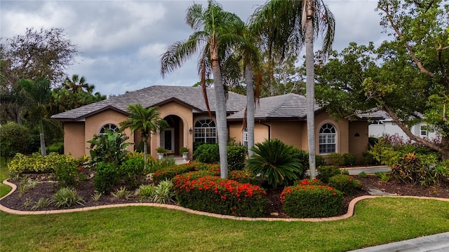 mediterranean / spanish-style house with a front yard