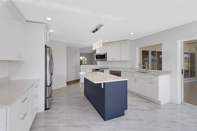 kitchen featuring pendant lighting, white cabinets, a center island, and stainless steel appliances