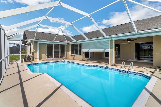 view of swimming pool featuring glass enclosure, a patio area, and ceiling fan