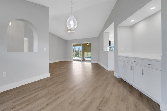 unfurnished dining area with light hardwood / wood-style floors, ceiling fan, and lofted ceiling