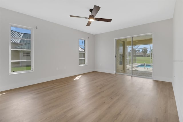 unfurnished room featuring light wood-type flooring, a wealth of natural light, and ceiling fan