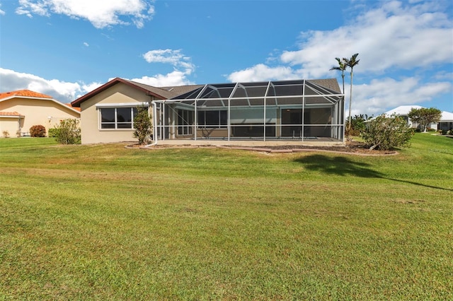 back of house featuring glass enclosure and a lawn