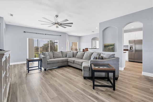 living room with ceiling fan and light wood-type flooring