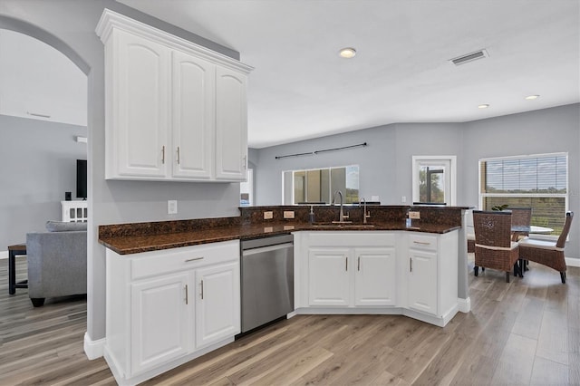 kitchen featuring dark stone countertops, sink, light wood-type flooring, stainless steel dishwasher, and white cabinetry