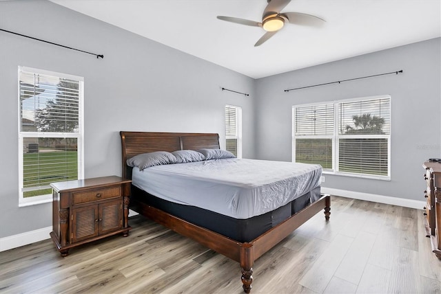 bedroom with light hardwood / wood-style flooring, ceiling fan, and multiple windows