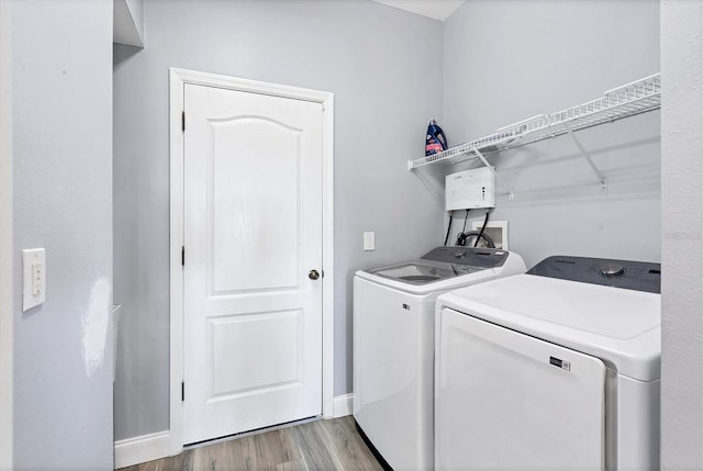 clothes washing area featuring light hardwood / wood-style flooring and washing machine and clothes dryer