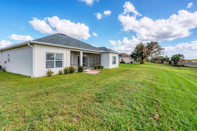 rear view of property featuring a lawn and a sunroom