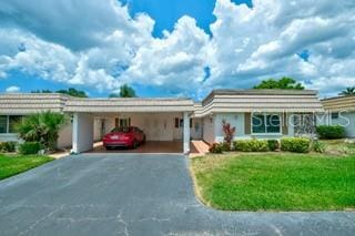 single story home featuring a front yard and a carport