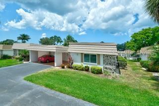 2609 Riverbluff Pkwy Unit 146, Sarasota, FL 34231 - view of front of property with asphalt driveway, a front yard, and a carport