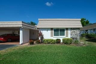 view of front facade featuring a front lawn and a carport