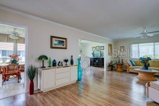 2609 Riverbluff Pkwy Unit 146, Sarasota, FL 34231 - living room with ceiling fan, ornamental molding, and wood finished floors