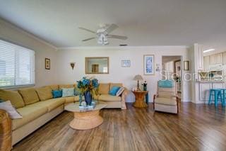 living room with crown molding, wood-type flooring, and ceiling fan