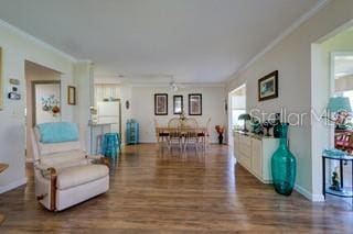 living room featuring ornamental molding and dark wood-type flooring