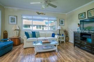 living room featuring a wealth of natural light, ornamental molding, hardwood / wood-style flooring, and ceiling fan