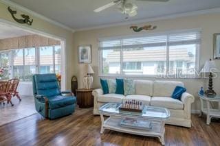 living room with ornamental molding, wood-type flooring, and ceiling fan